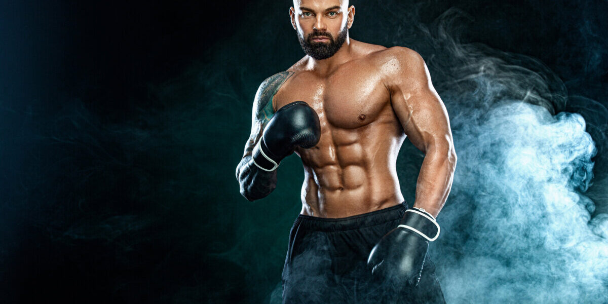Fitness and boxing concept. Boxer, man fighting or posing in gloves on black background. Individual sports recreation.