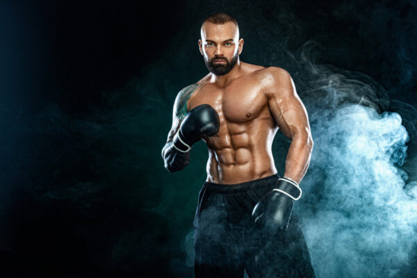 Fitness and boxing concept. Boxer, man fighting or posing in gloves on black background. Individual sports recreation.