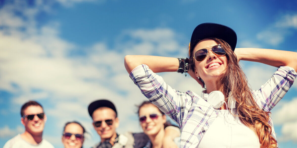 teenage girl with headphones and friends outside